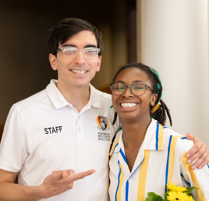 male and female student posing together, man has arm wrapped around woman