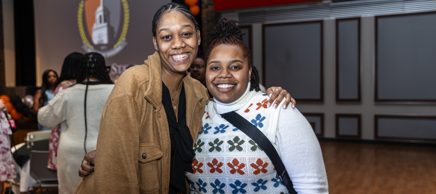 two young women standing next to each other smiling